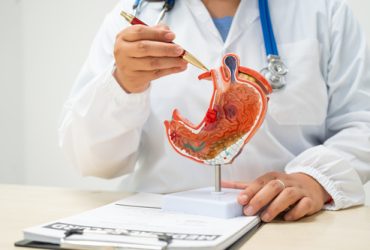 A female doctor a hospital desk discussing digestive disorders such as stomach ulcers,acid reflux